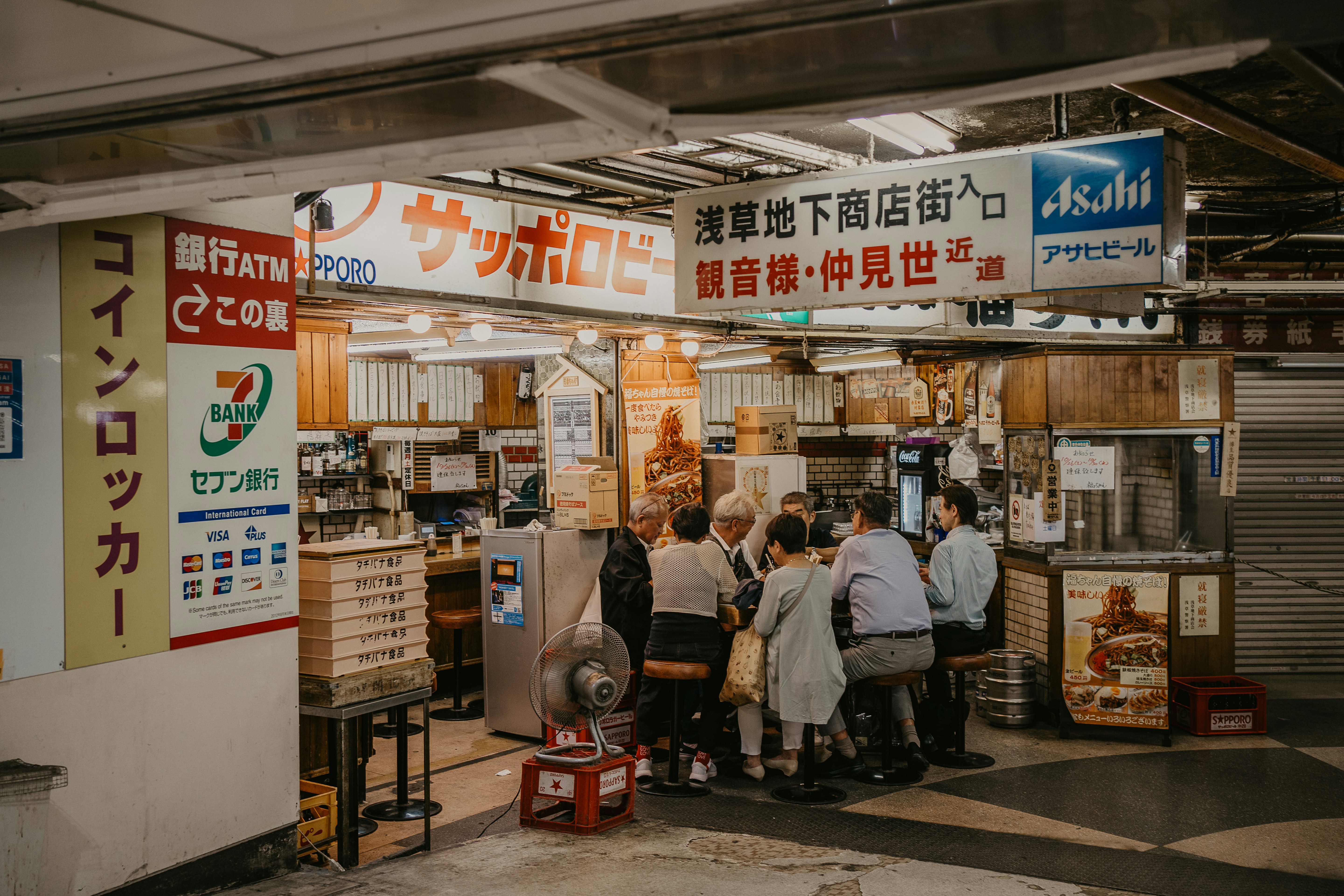 A group of people standing in front of a store