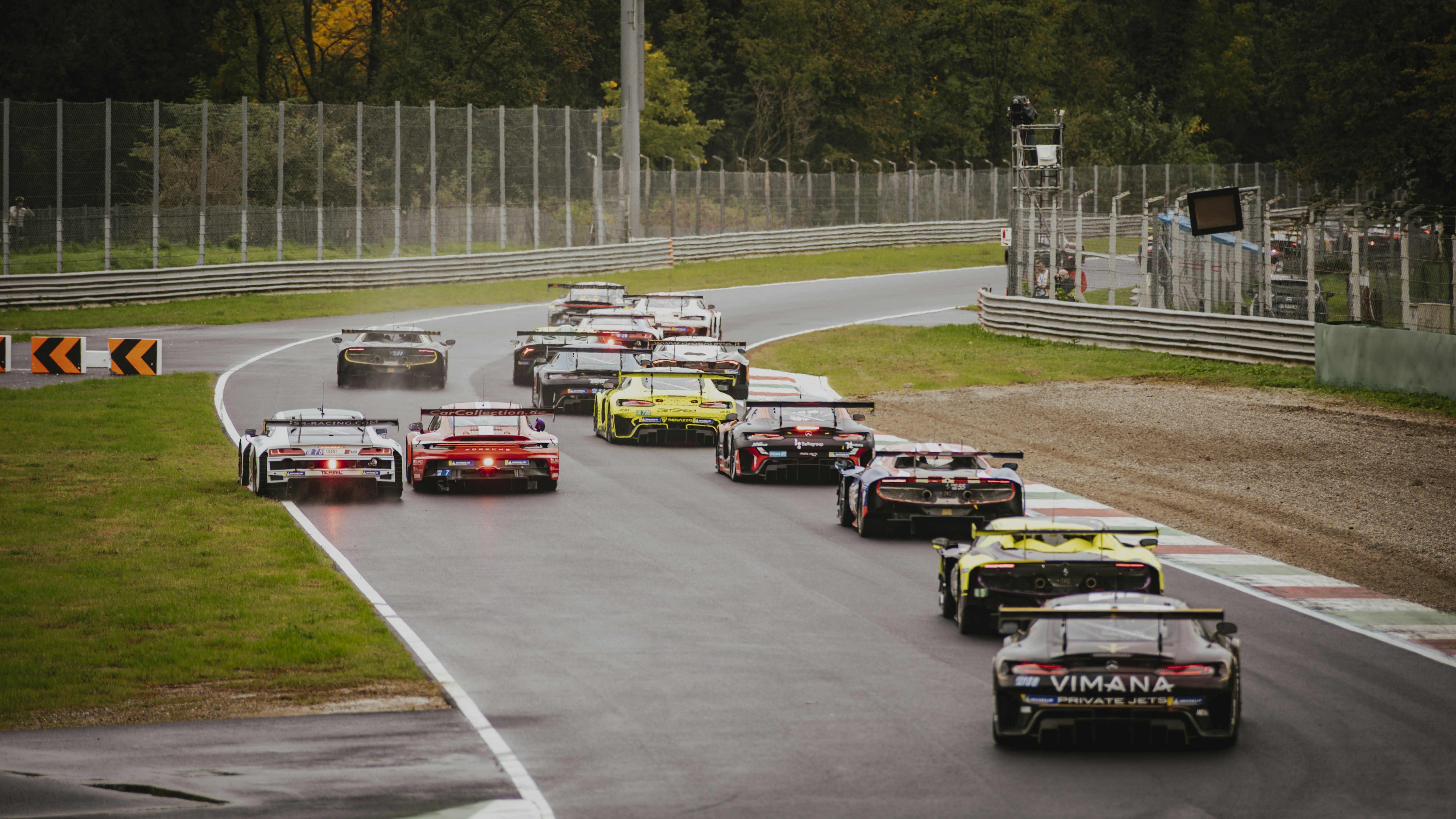 A group of cars driving down a race track