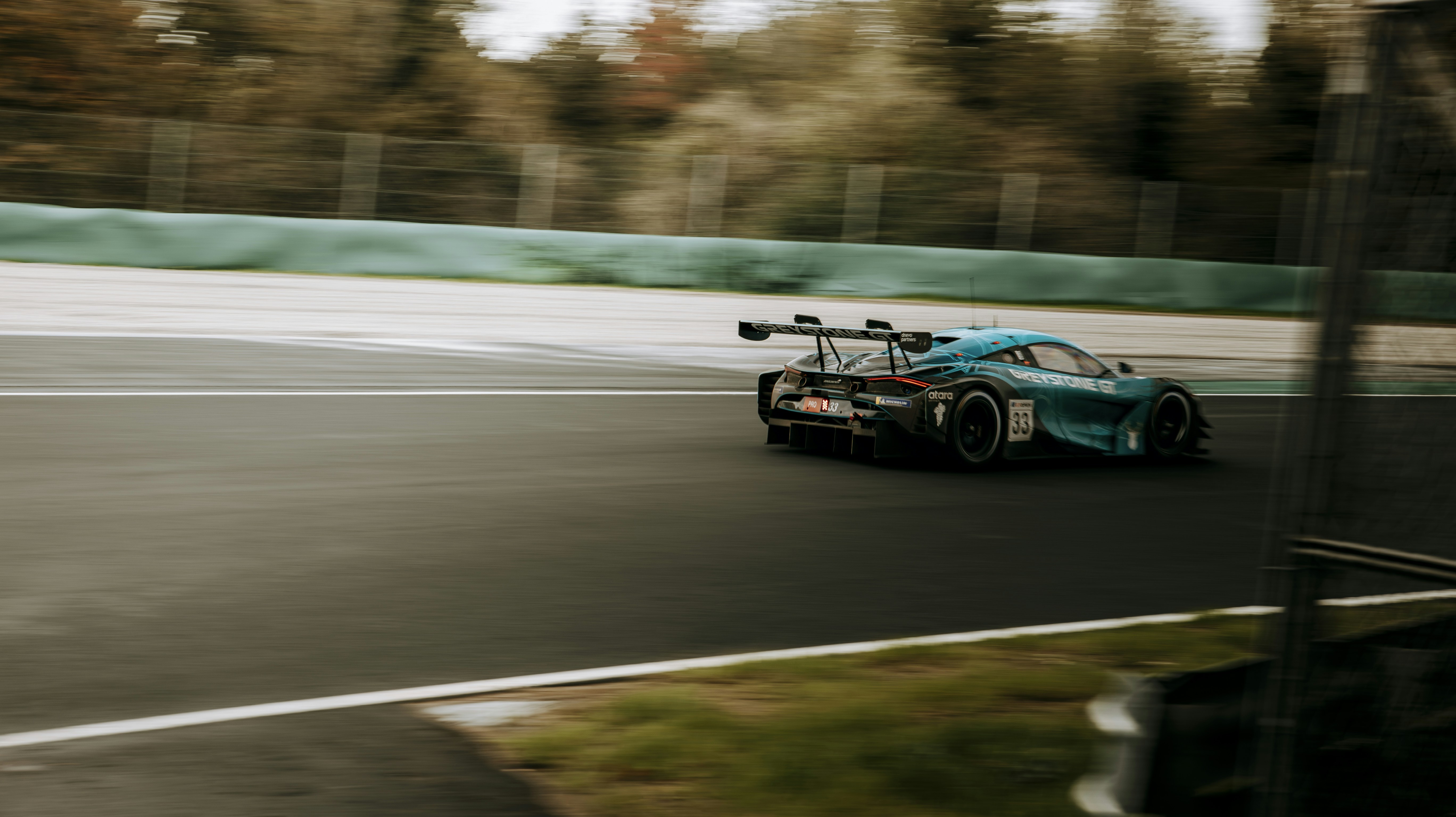 A blue race car driving down a race track