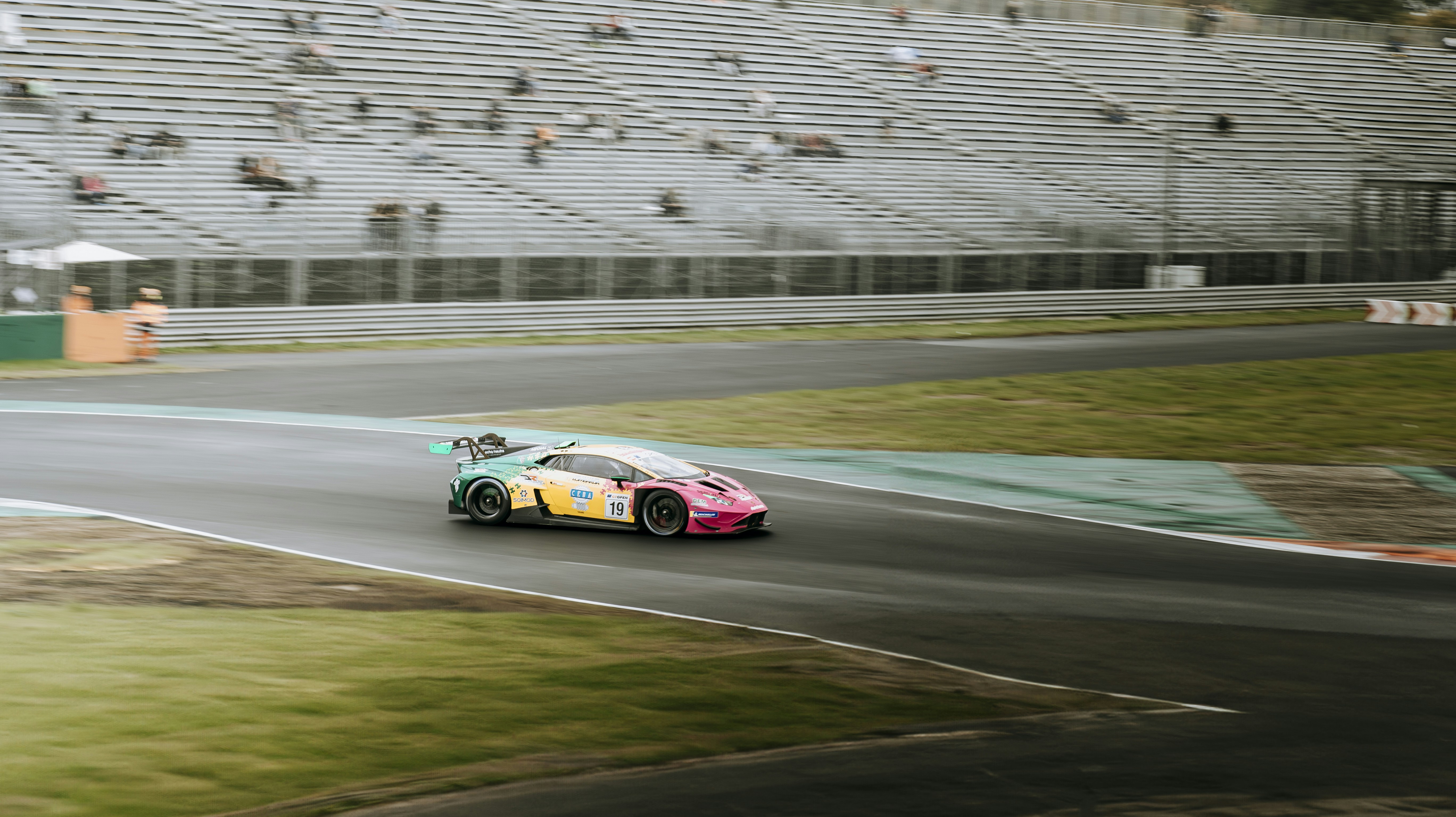 A car driving down a race track in front of a crowd