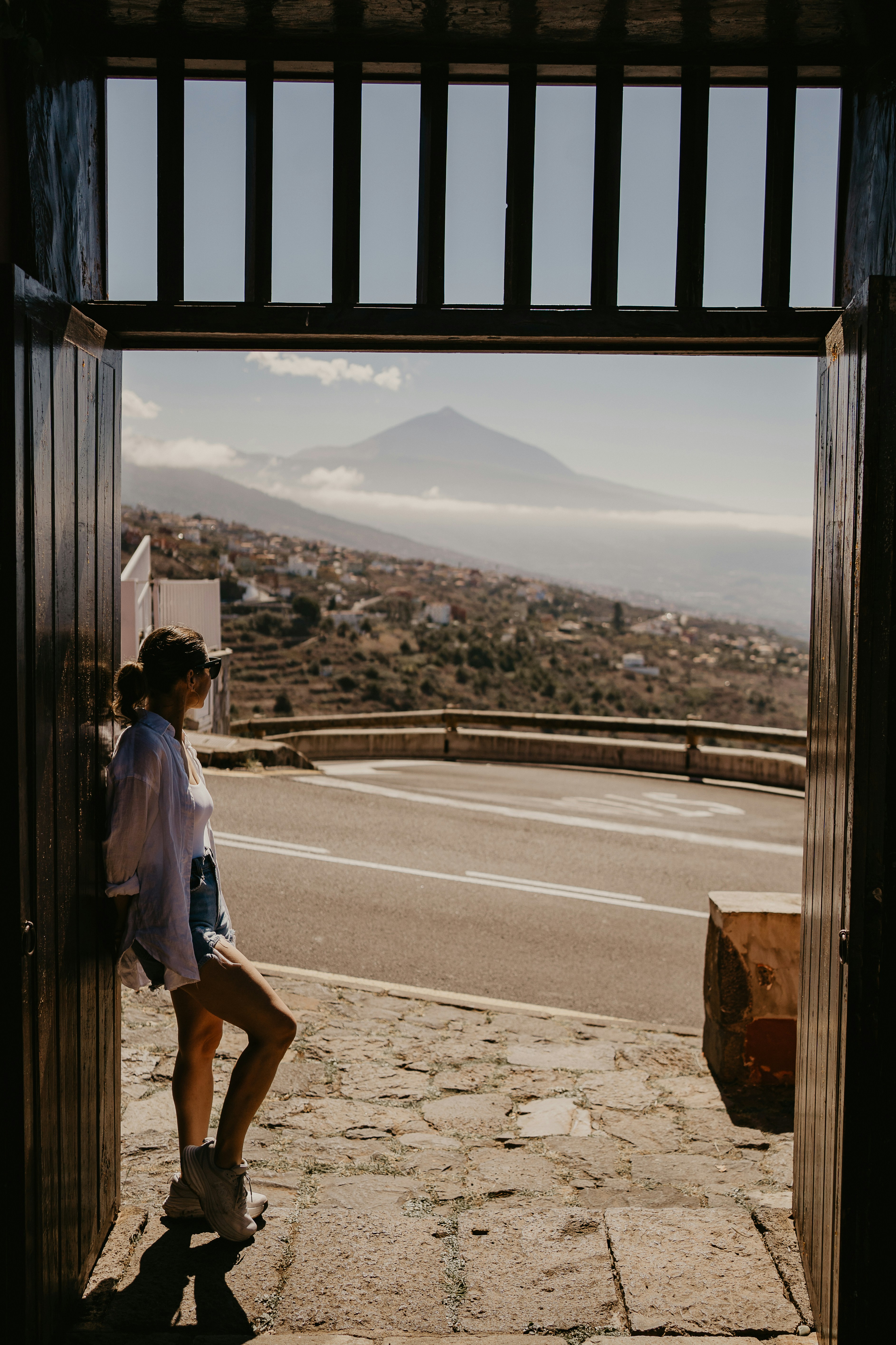 A woman standing in an open doorway with a mountain in the background