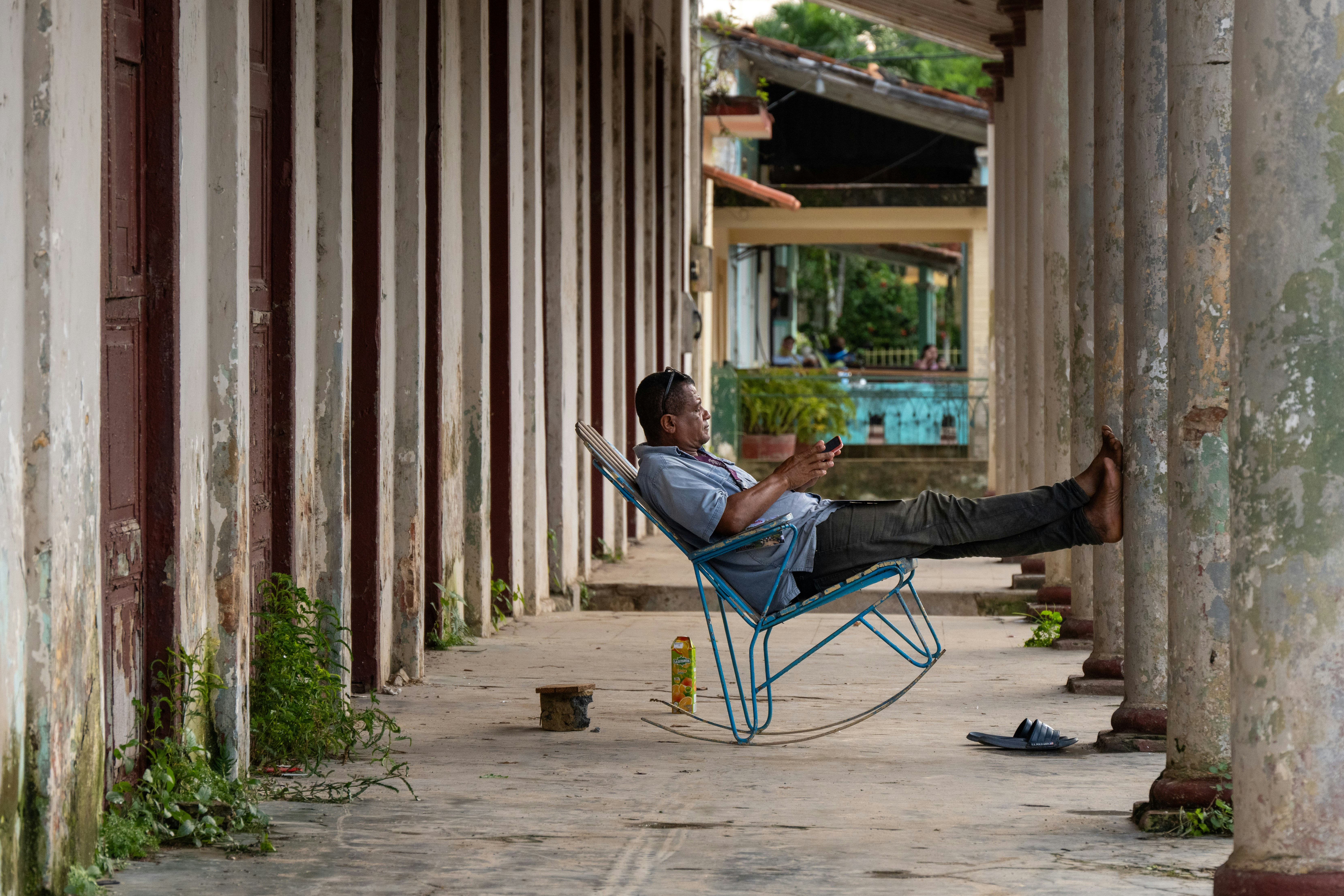 Ein Mann sitzt auf einem Stuhl unter einer Brücke