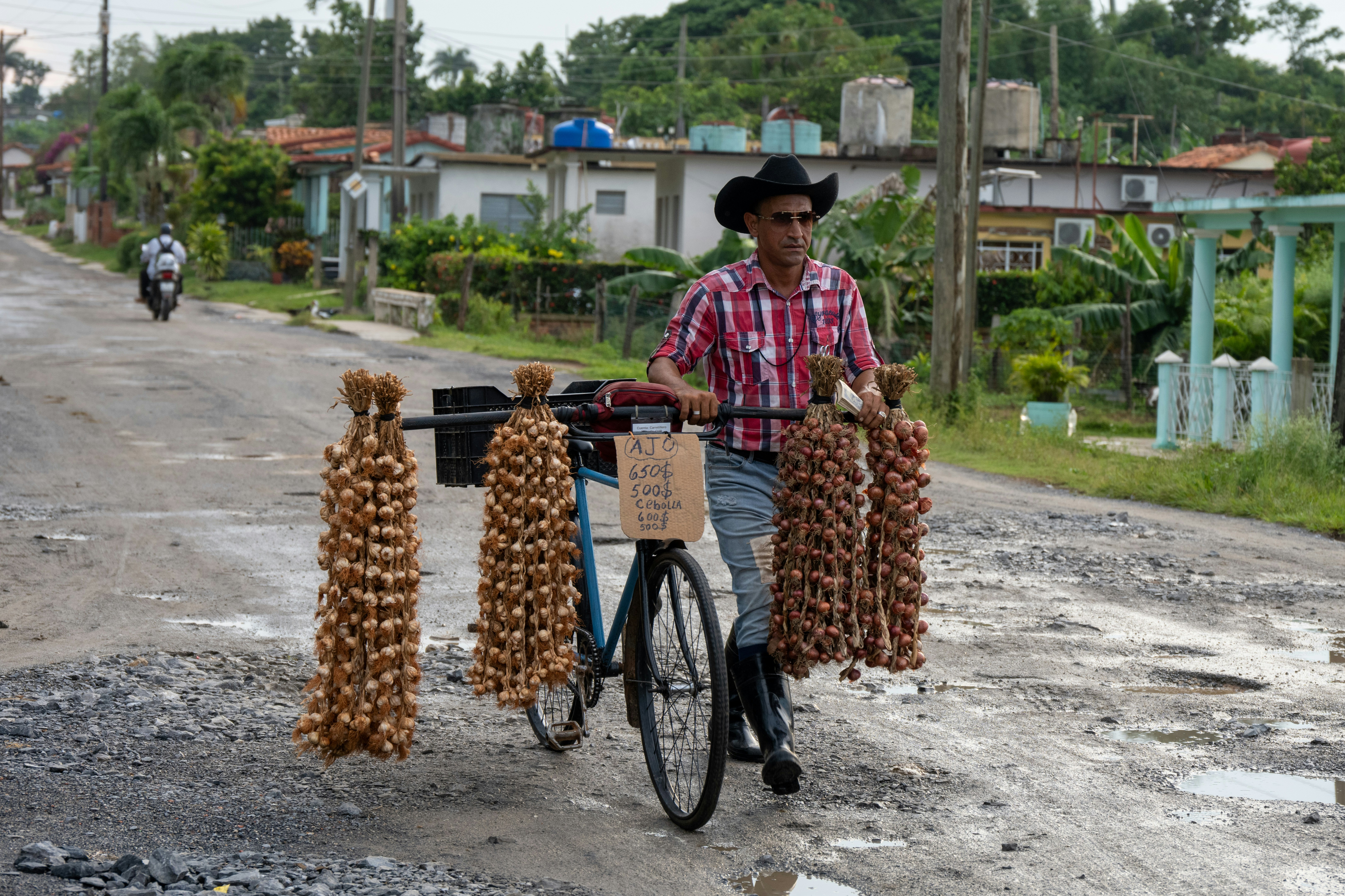 Ein Mann fährt mit einem Fahrrad eine unbefestigte Straße hinunter