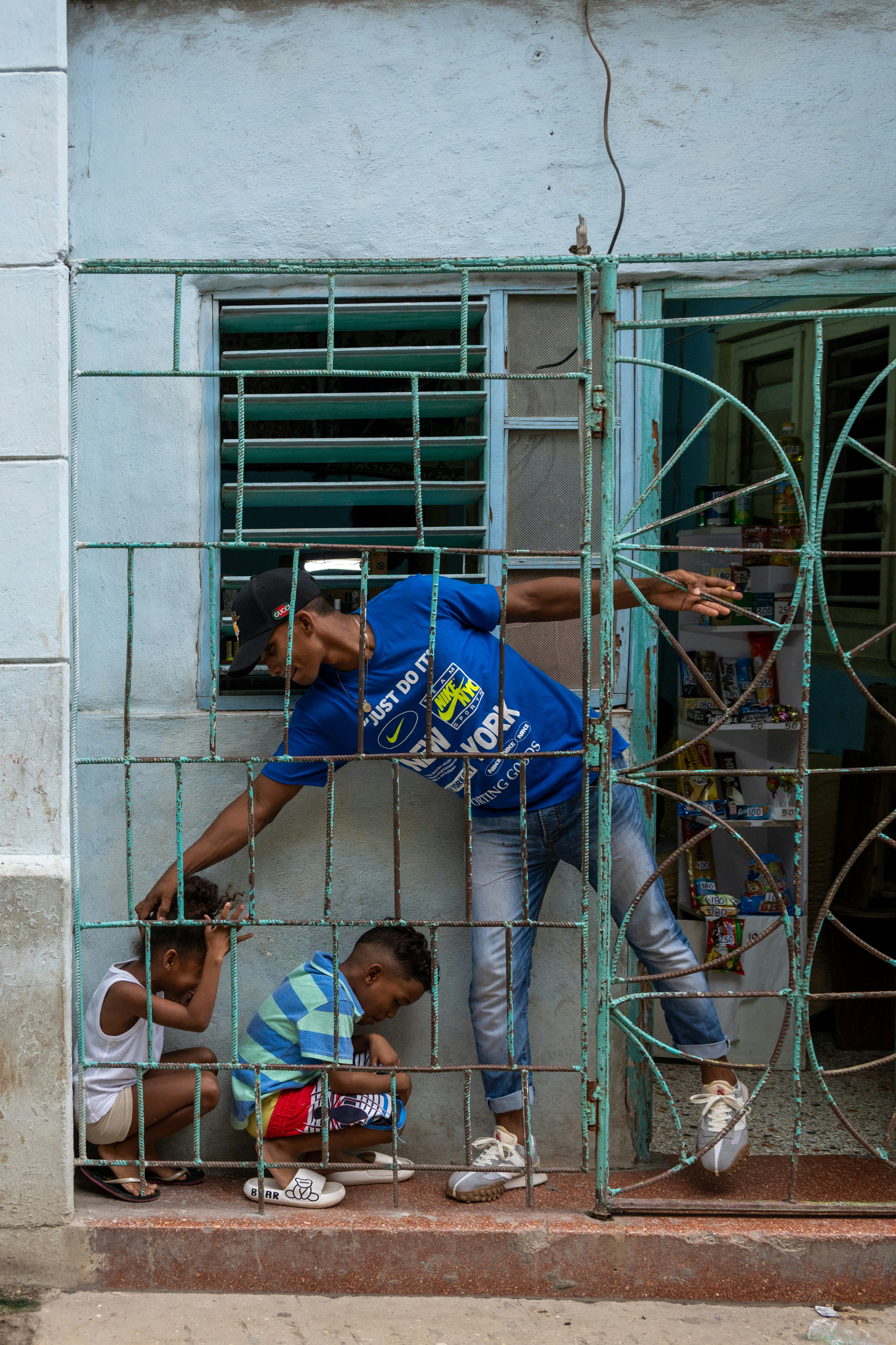 Eine Gruppe von Menschen, die hinter Gittern vor einem Gebäude stehen