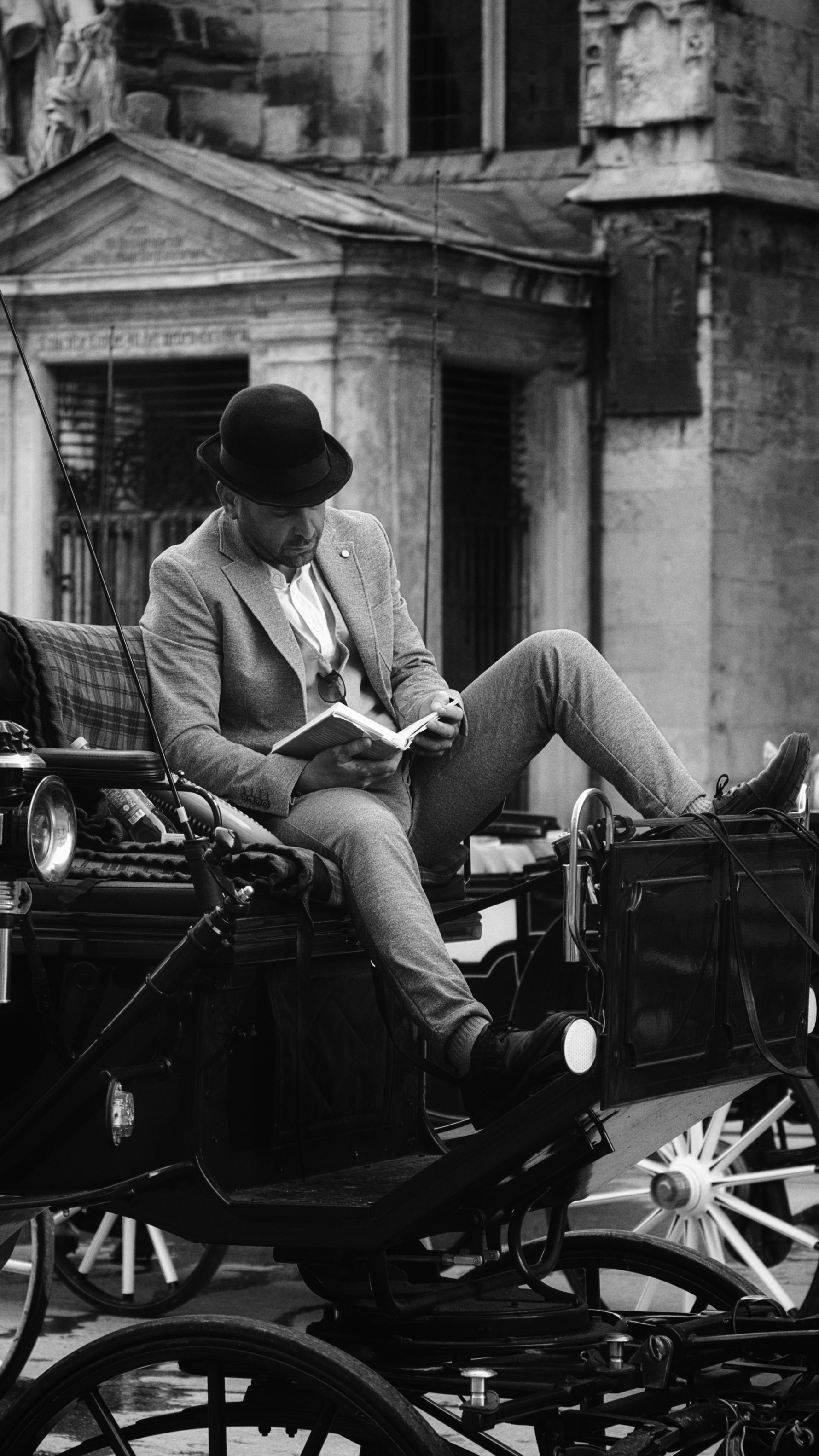 A man sitting in a horse drawn carriage