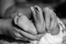 A black and white photo of a person holding a baby