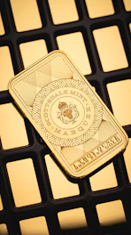 A gold bar sitting on top of a computer keyboard
