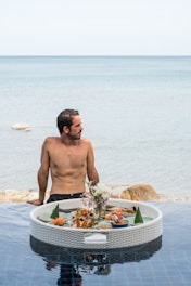 A man sitting on the edge of a swimming pool