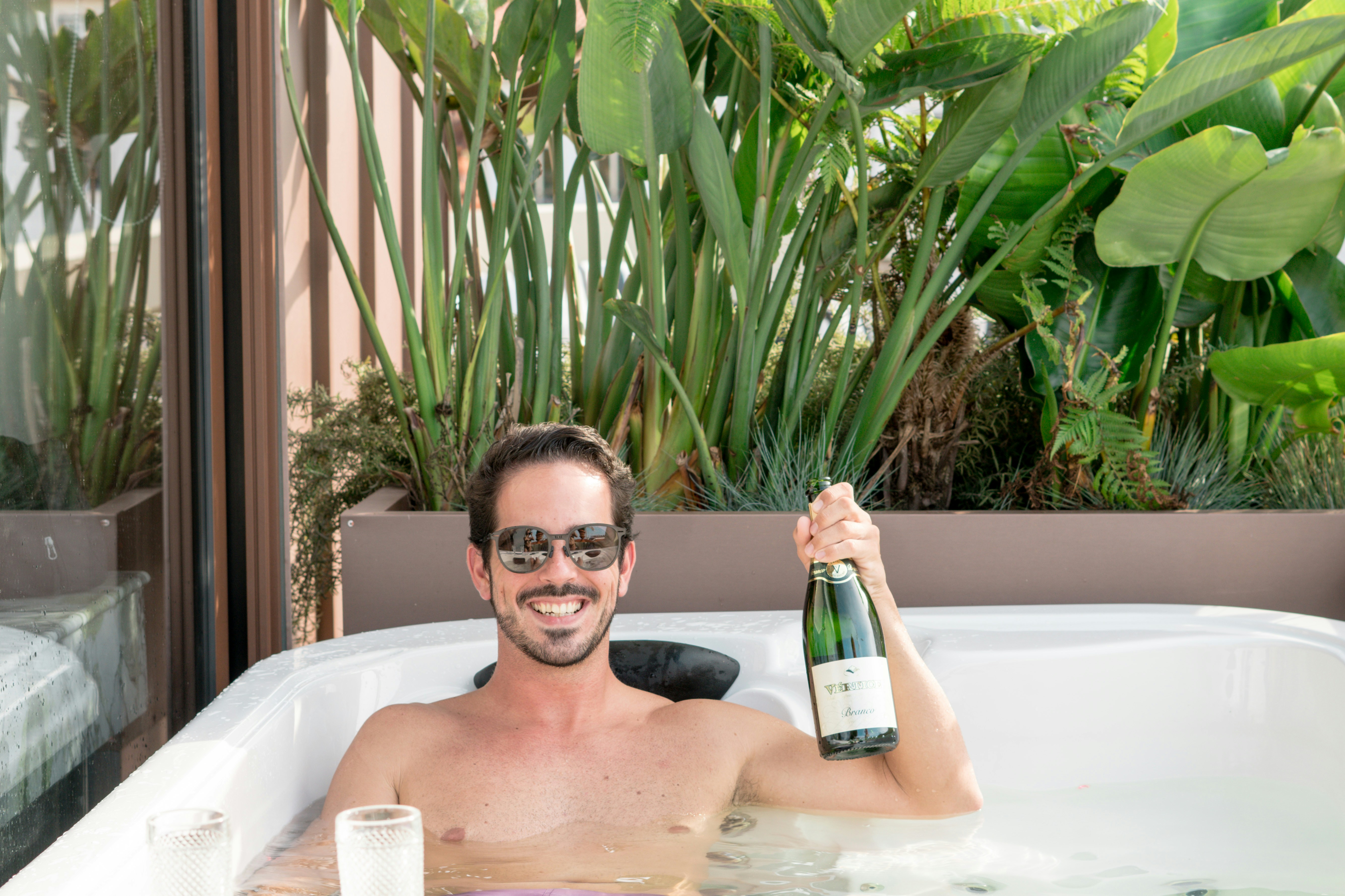 Man in hot tub with wine