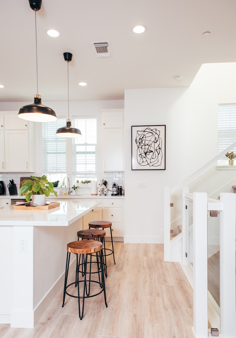 A kitchen with a wooden floor and white walls
