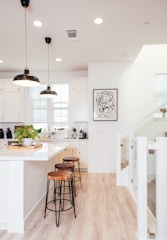 A kitchen with a wooden floor and white walls
