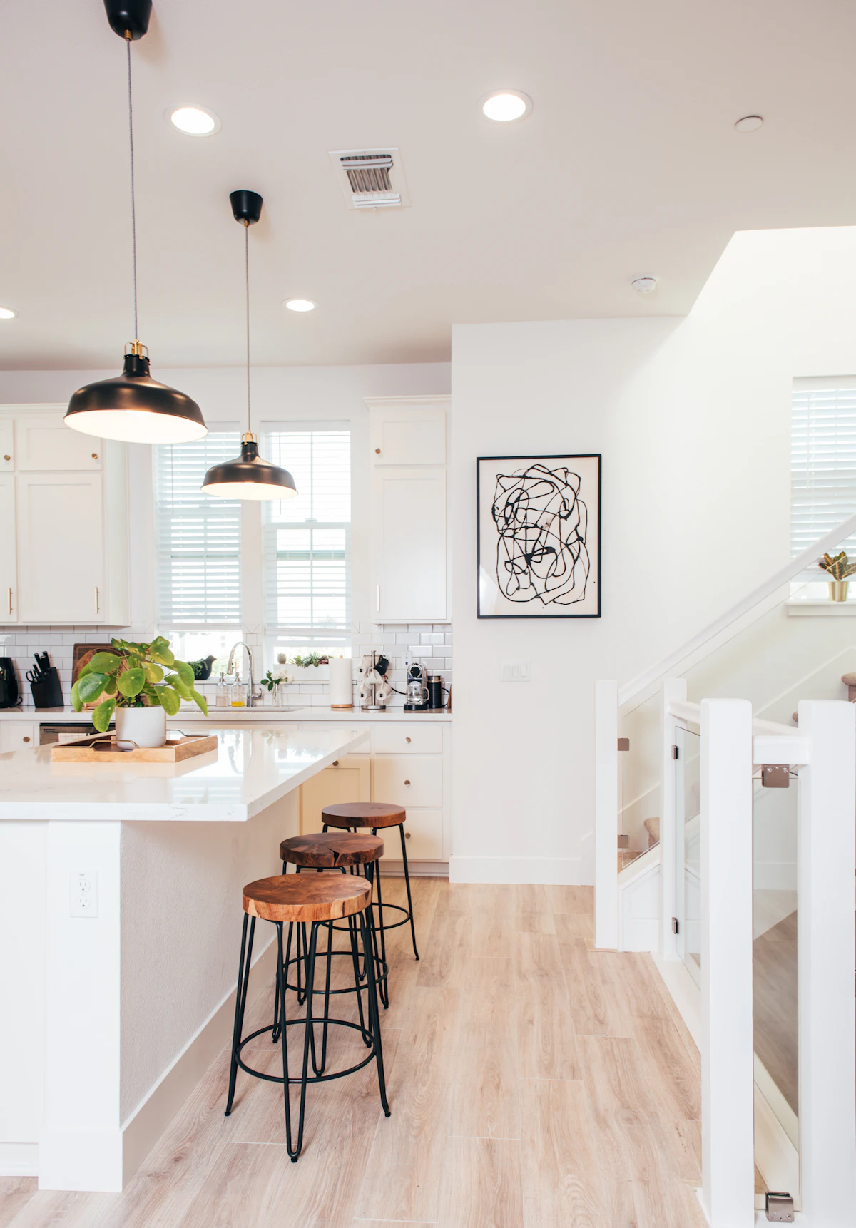 White kitchen with a center island over light luxury vinyl plank.