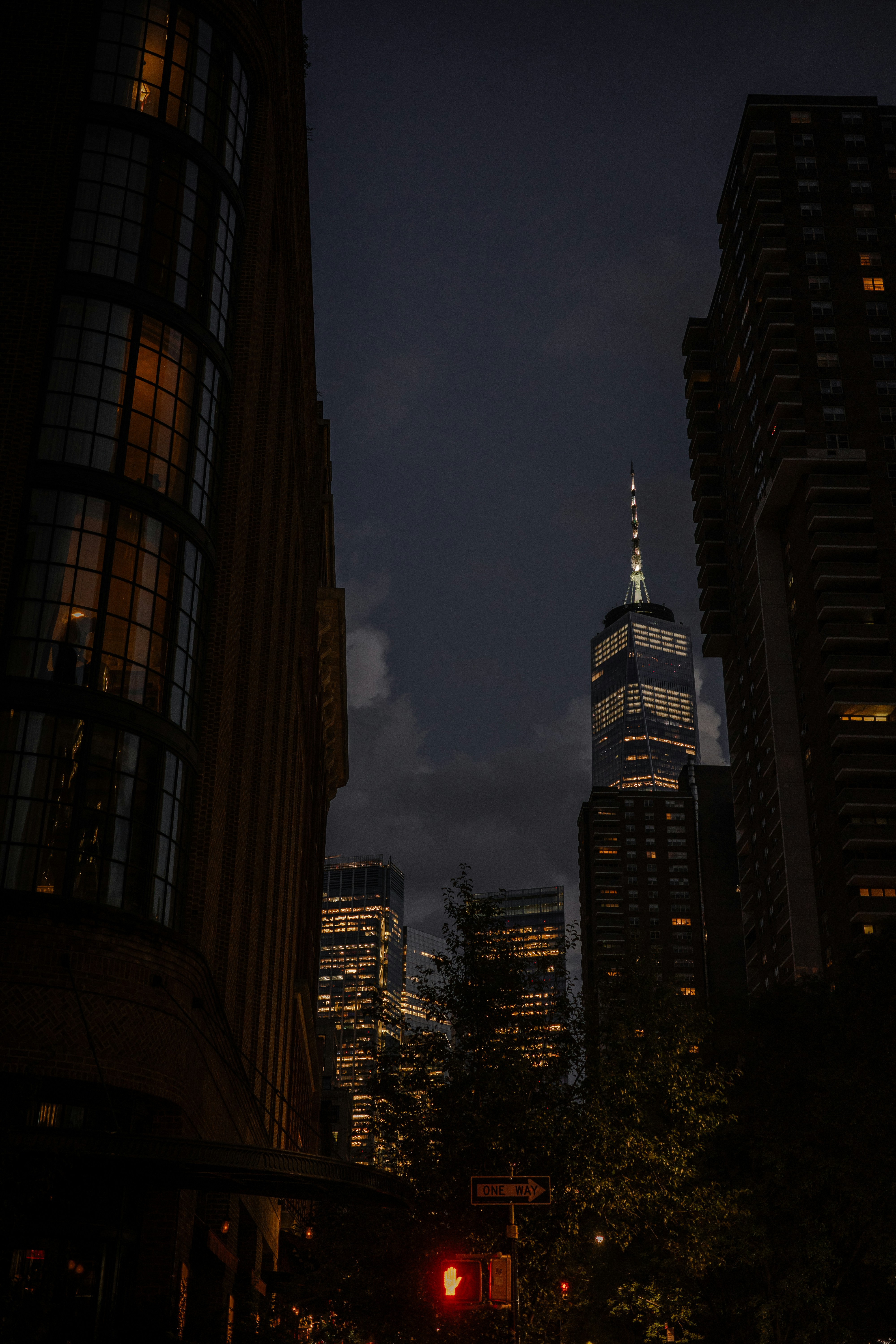 A city street at night with tall buildings photo – Free City Image on ...