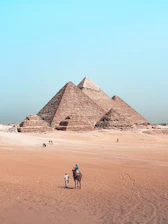 A man riding a horse in front of the pyramids of giza