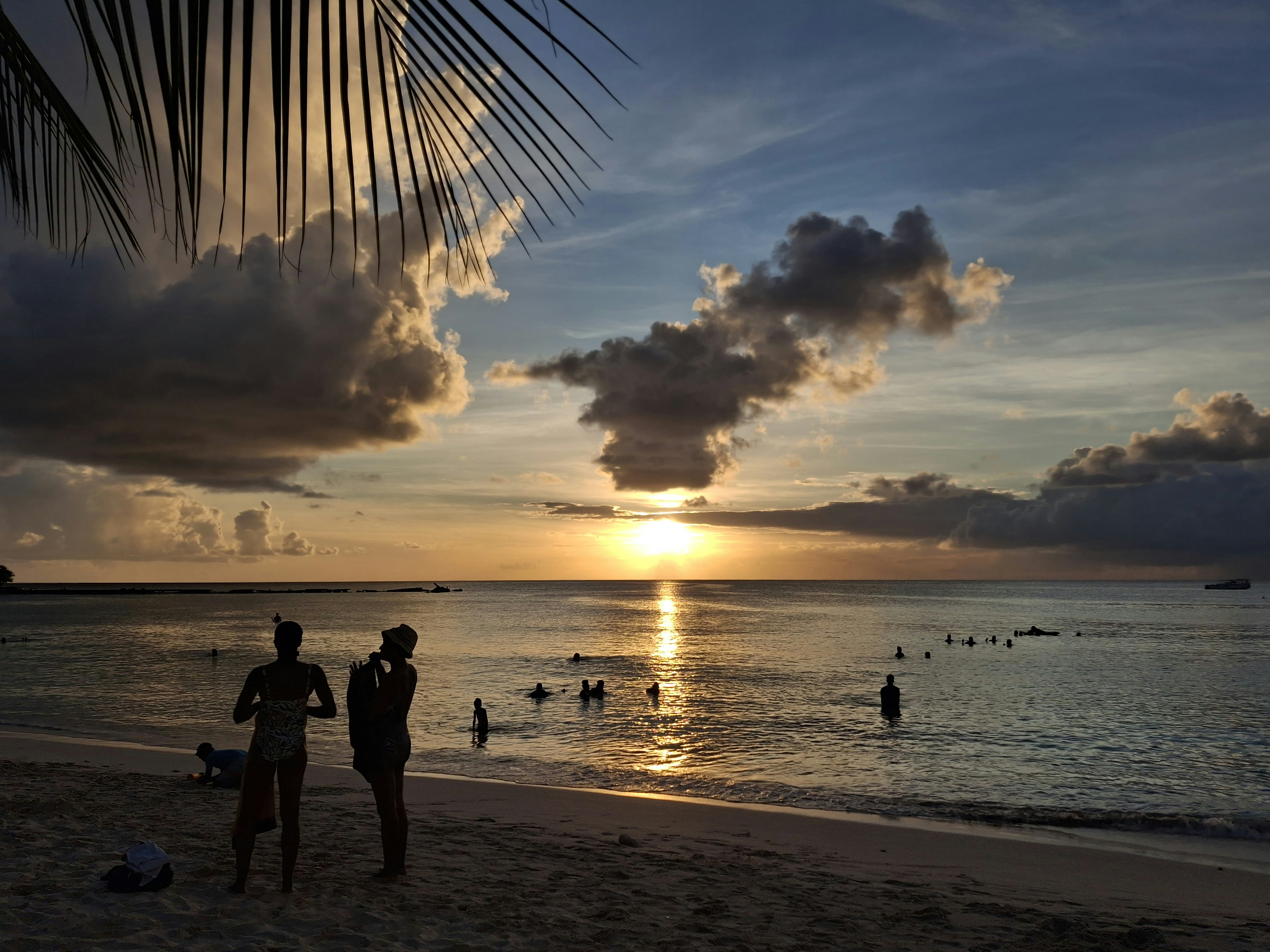 A group of people standing on top of a sandy beach