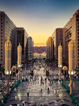 A group of people walking down a street next to tall buildings