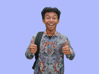 A man with a backpack giving a thumbs up