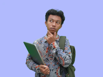 A man with a backpack looking at a laptop