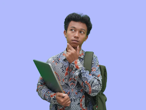 A man with a backpack looking at a laptop
