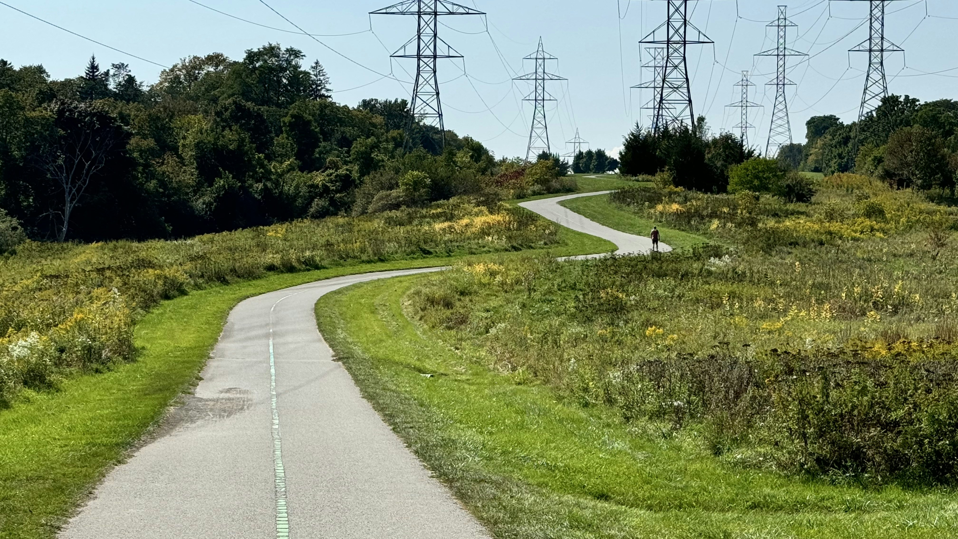 A winding road with power lines in the background