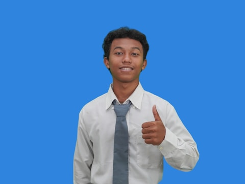 A man in a tie giving a thumbs up