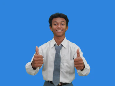 A man in a tie giving a thumbs up