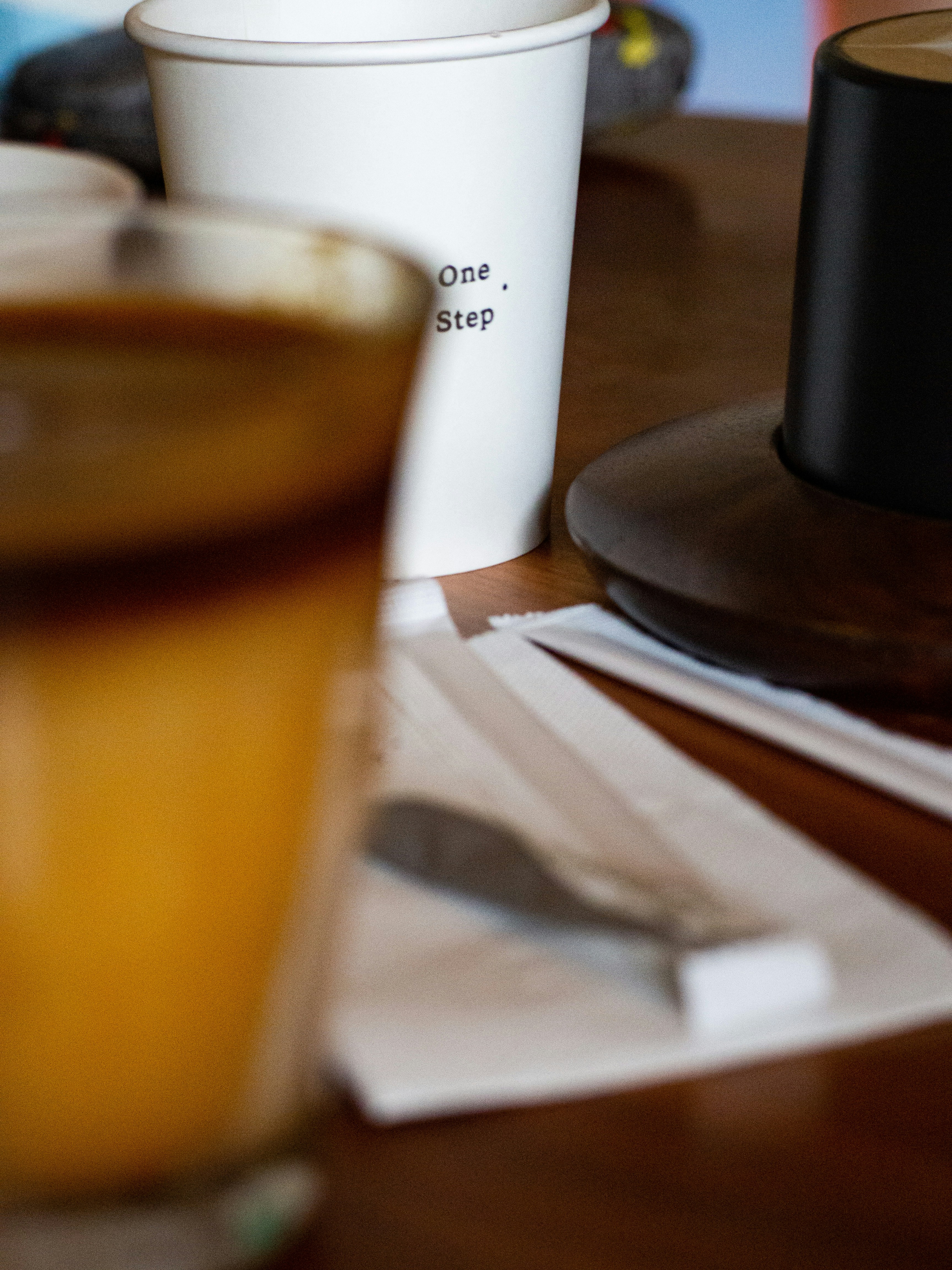 A wooden table topped with cups of coffee