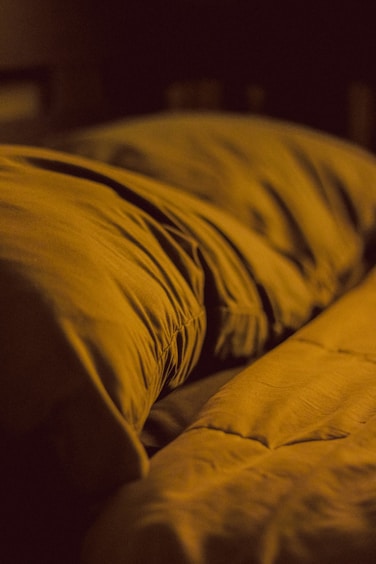 A close up of a yellow comforter on a bed