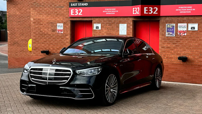 Luxury black car waiting at a building entrance