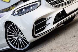 A white sports car parked on the side of the road