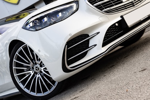 A white sports car parked on the side of the road
