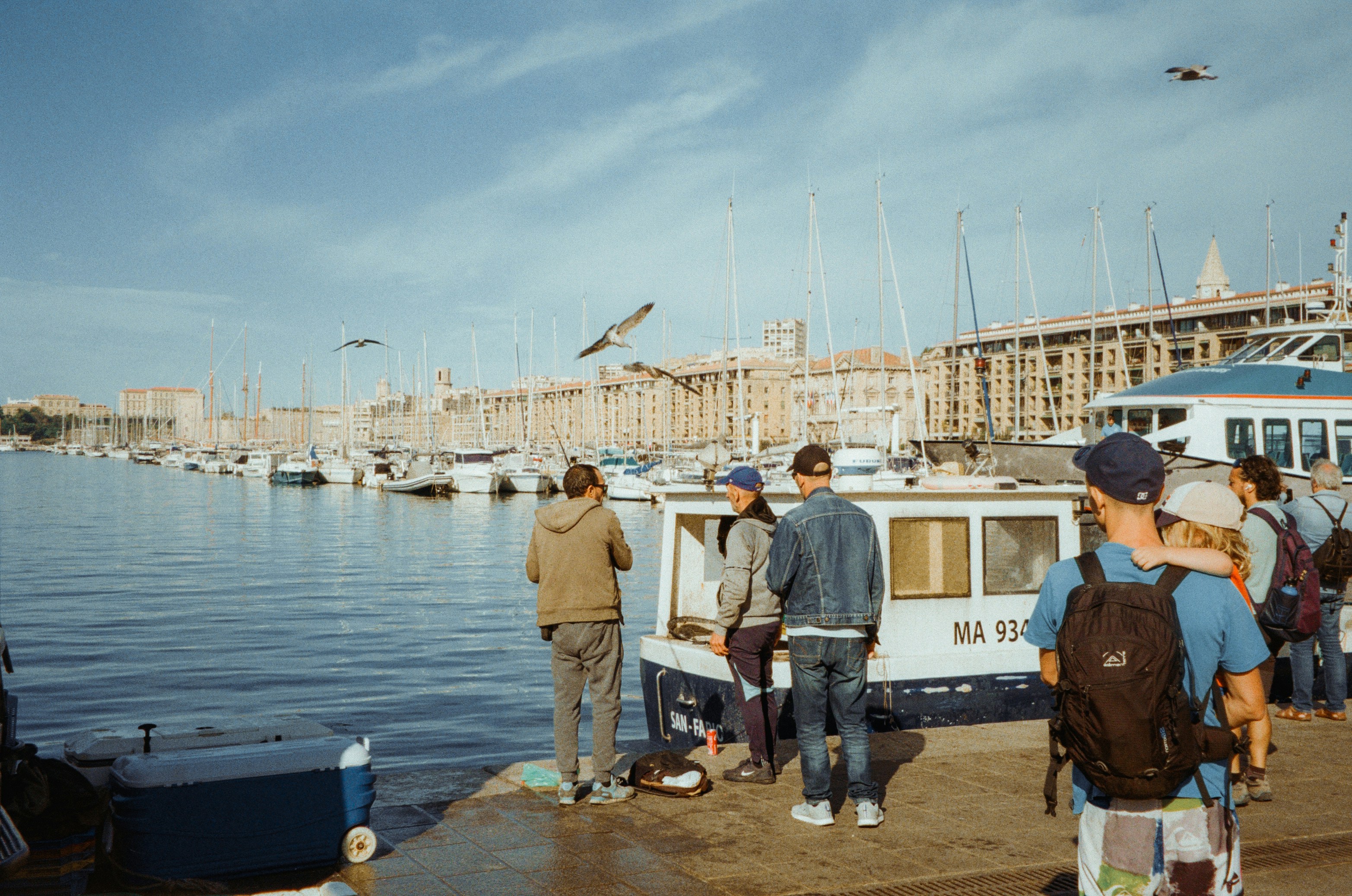 A group of people standing next to a body of water