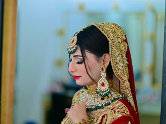 A woman in a red and gold bridal outfit