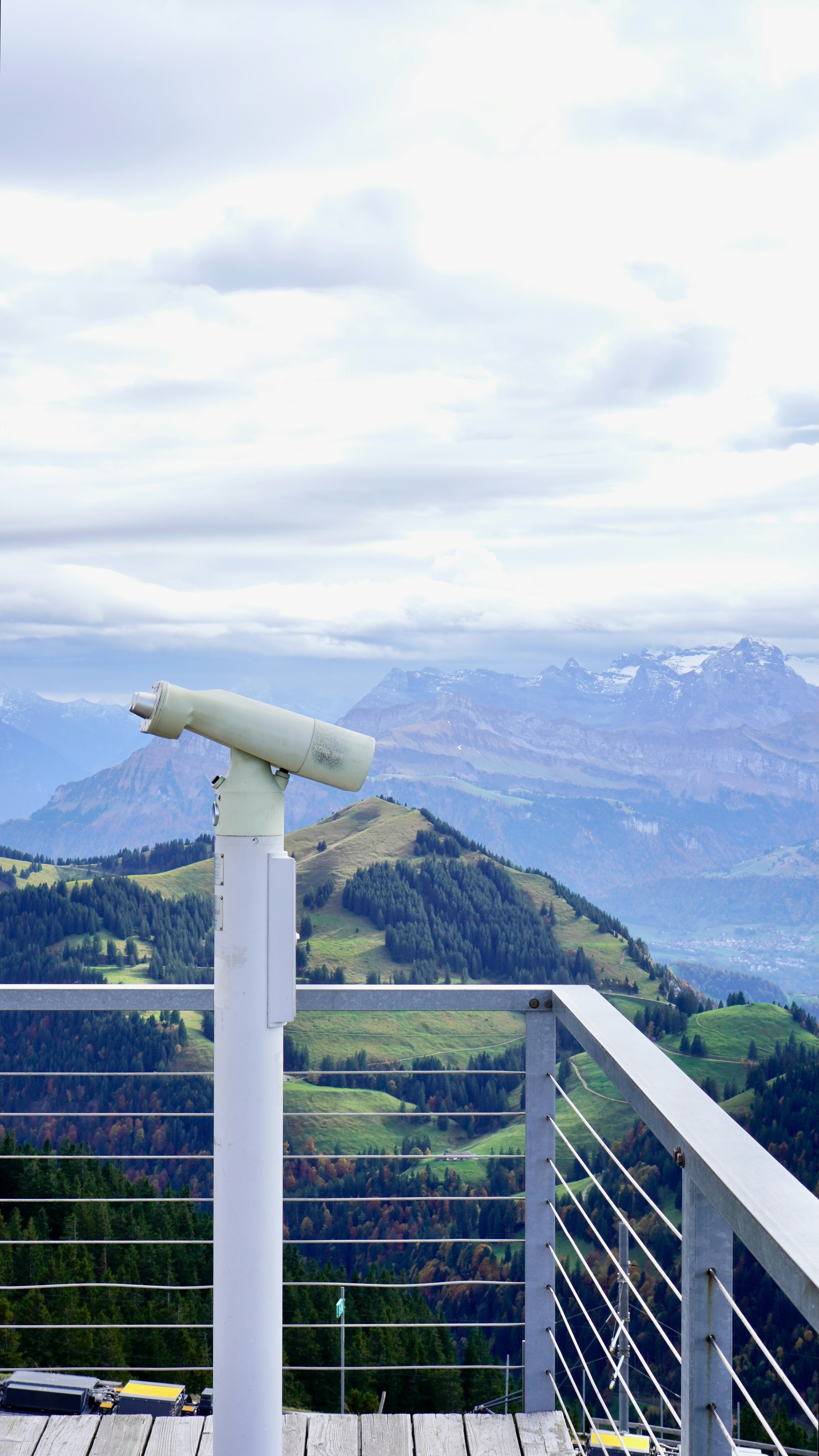 A telescope sitting on top of a wooden deck