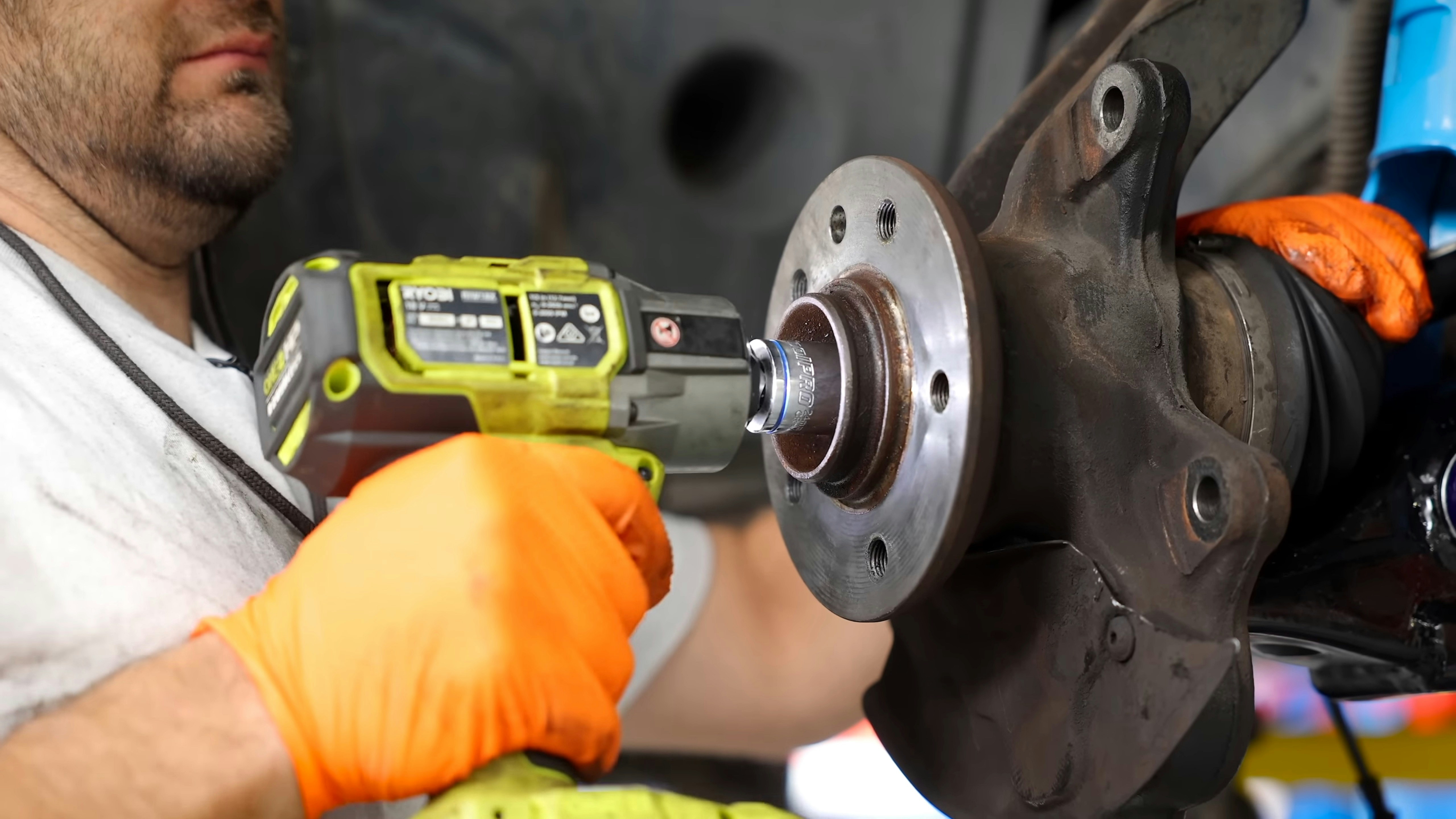 Auto technician inspecting front brake components with wheel removed