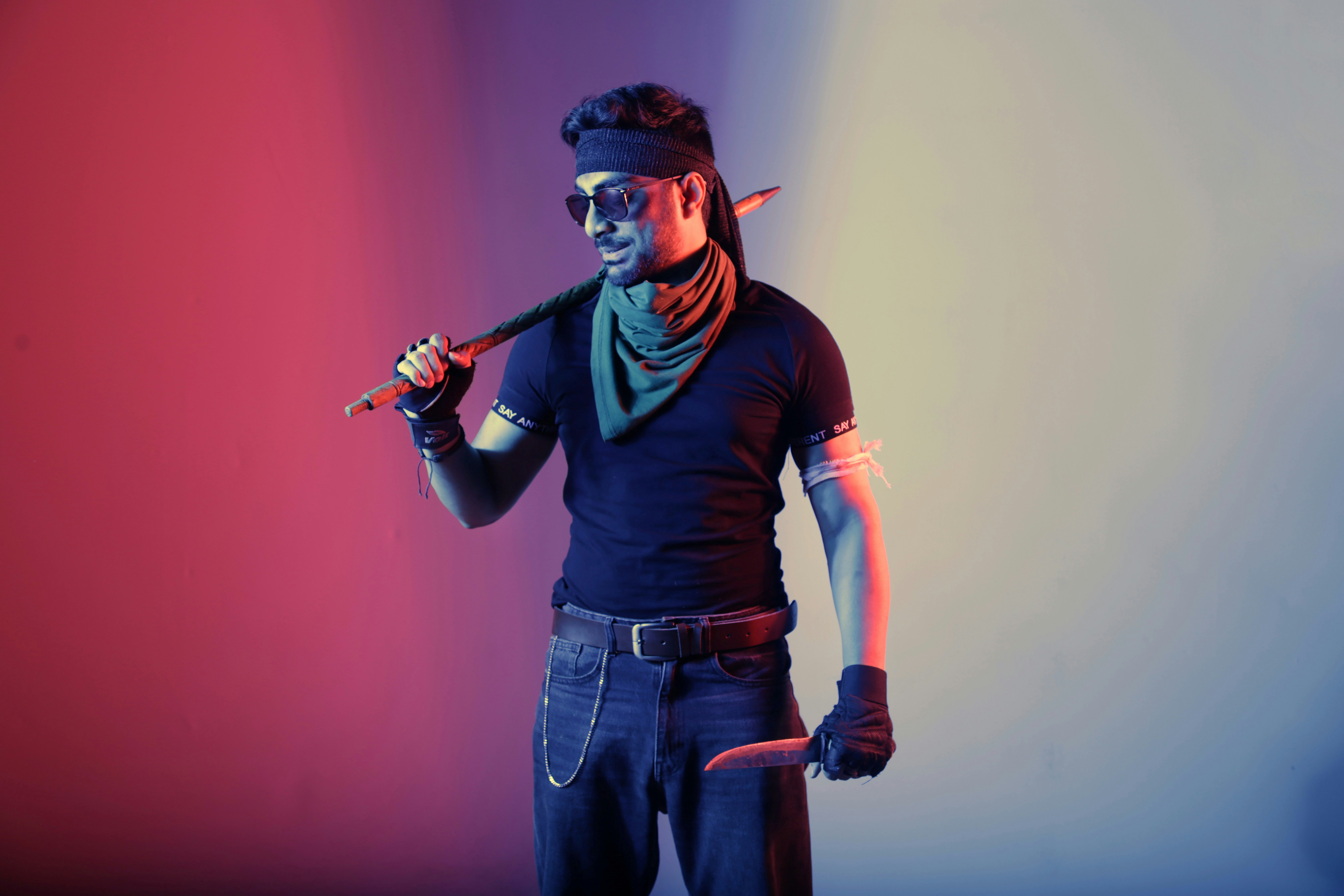 A man with a baseball bat standing in front of a colored background