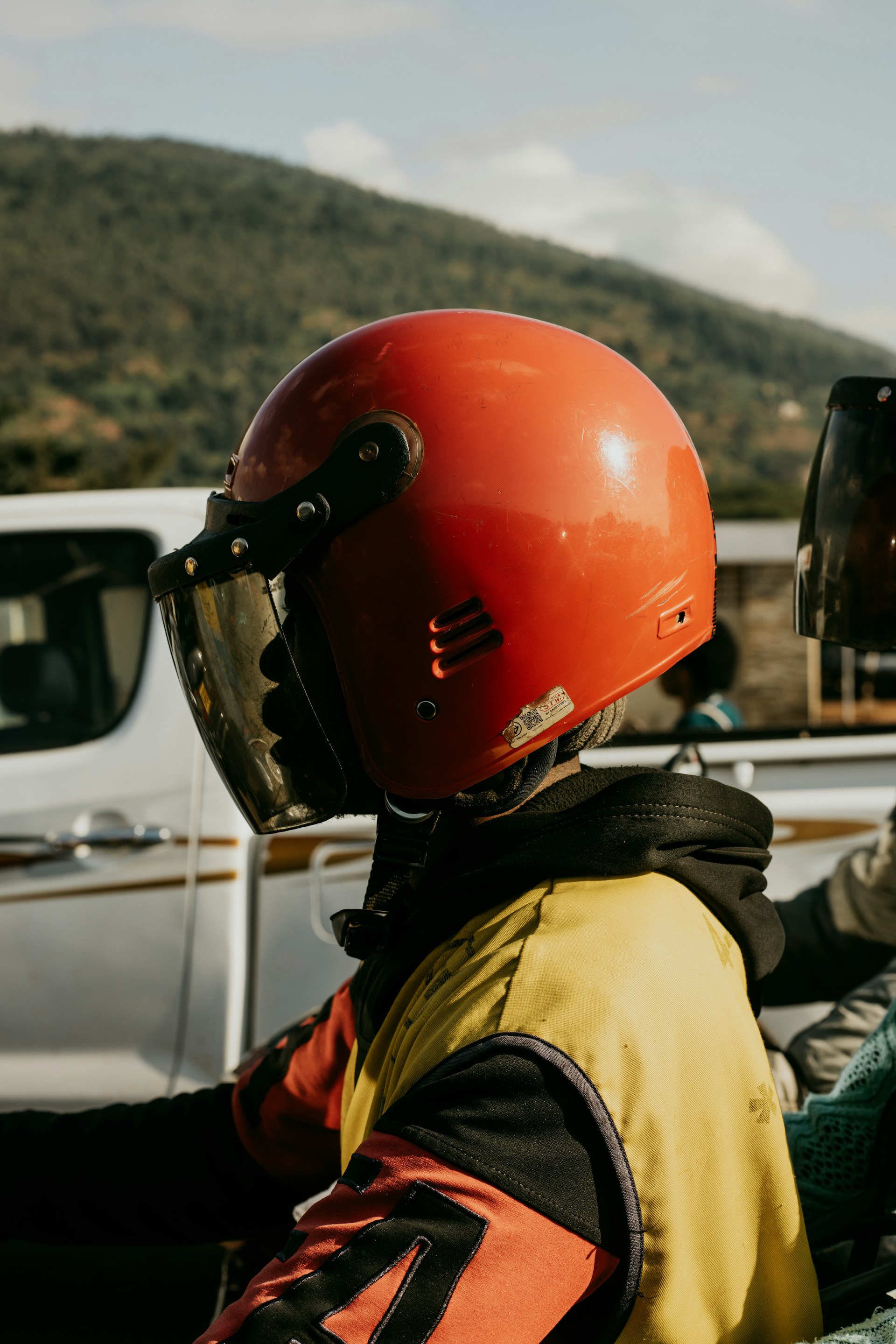 A person wearing a helmet sitting in the back of a truck