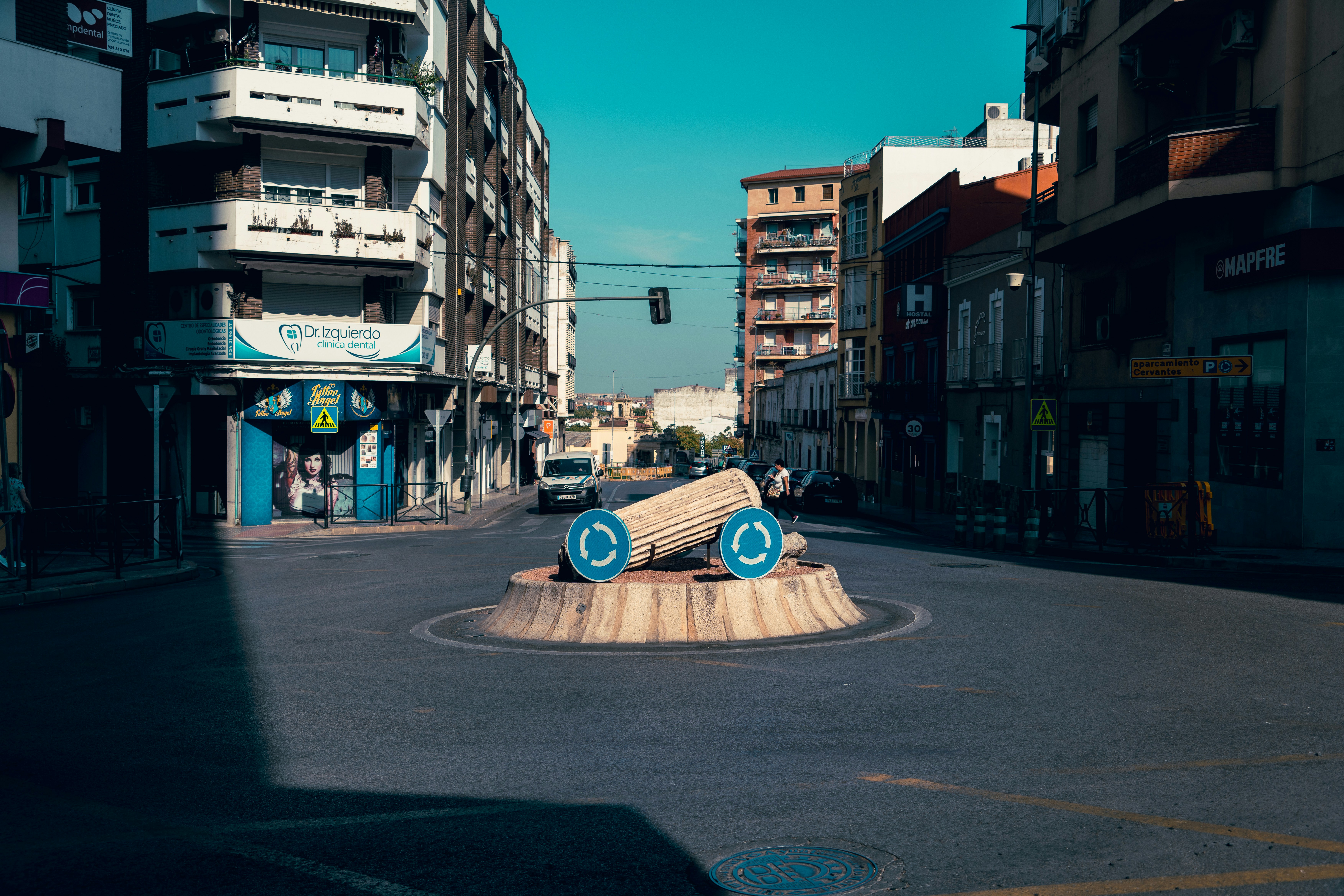 A skateboarder is doing a trick in the middle of the street