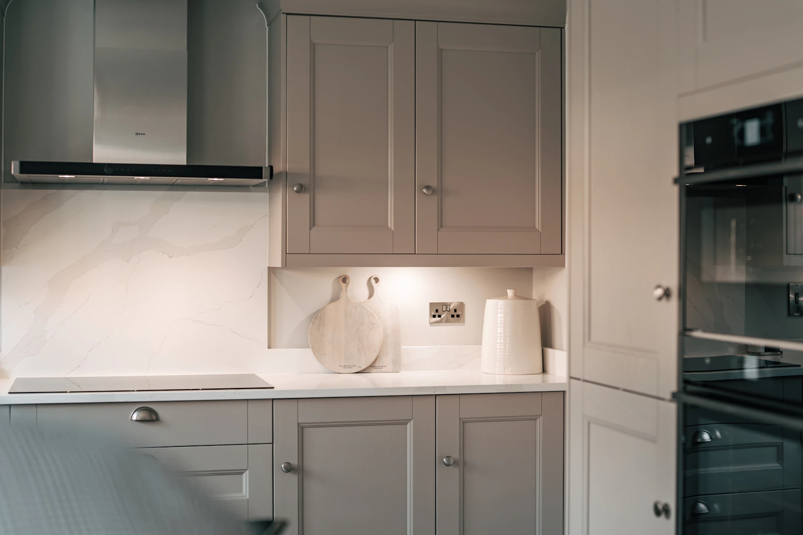 Grey shaker kitchen units with marble splashback and UK double socket