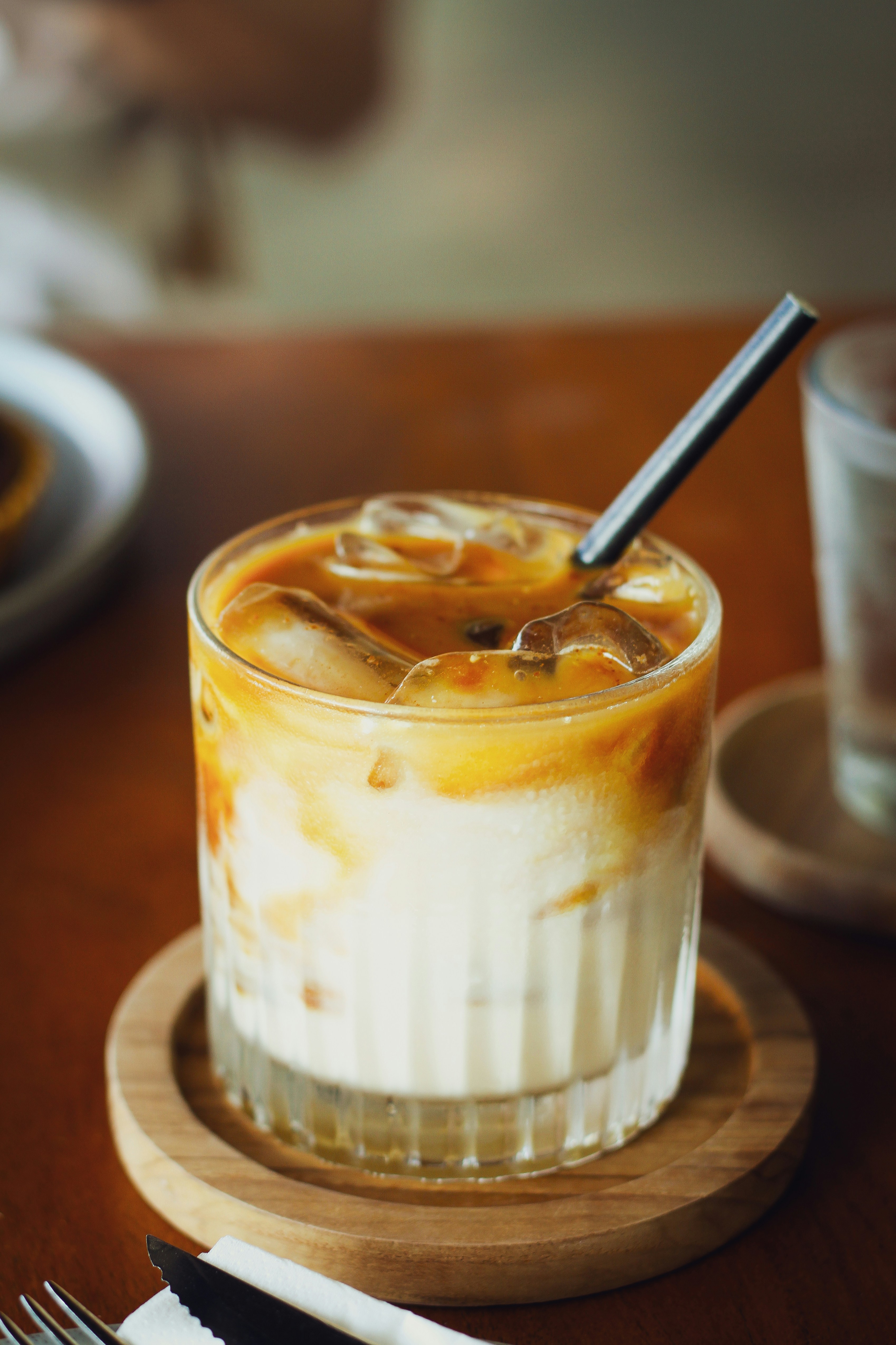 A glass of iced coffee sitting on top of a wooden table