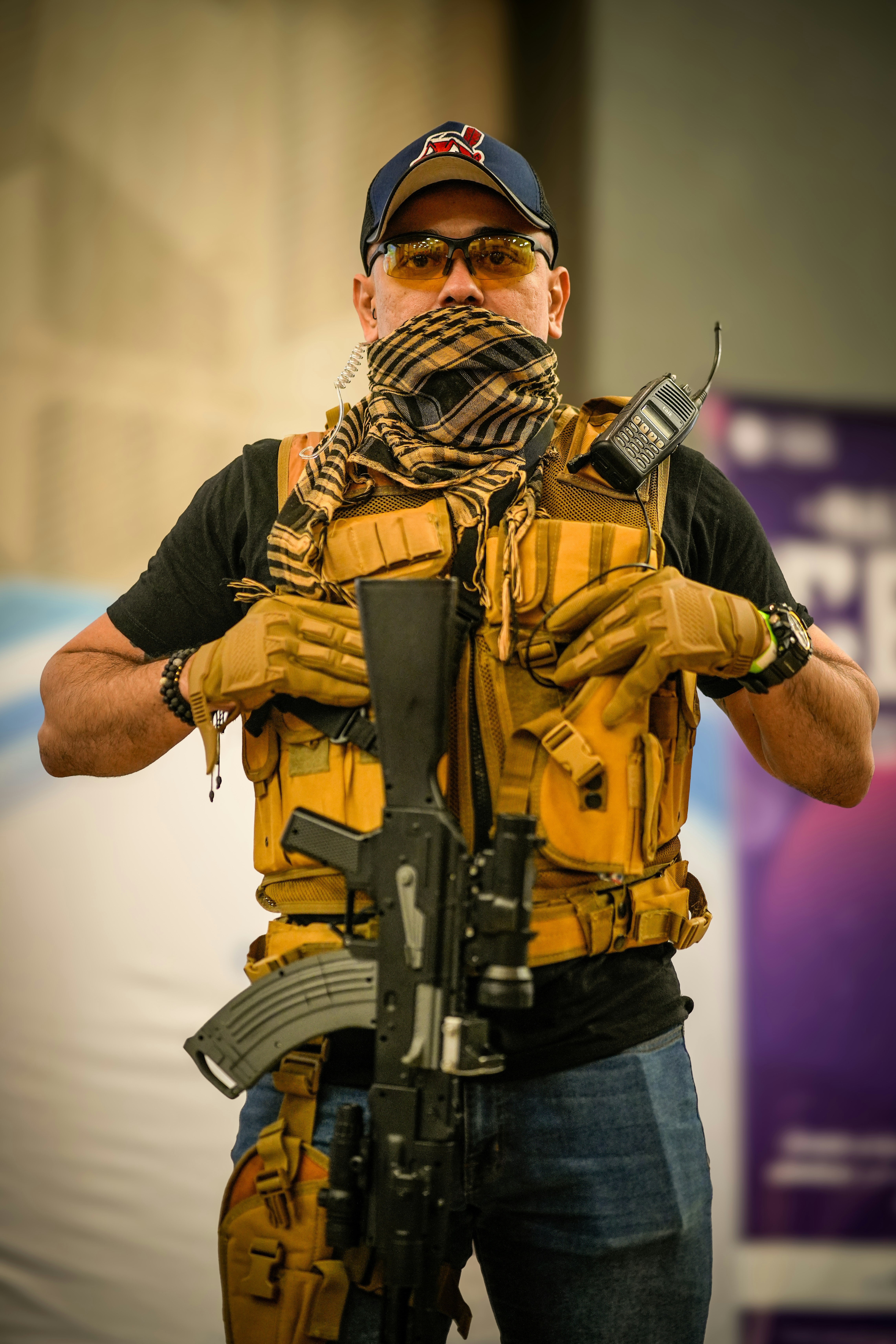 Seorang pria berrompi kuning memegang pistol