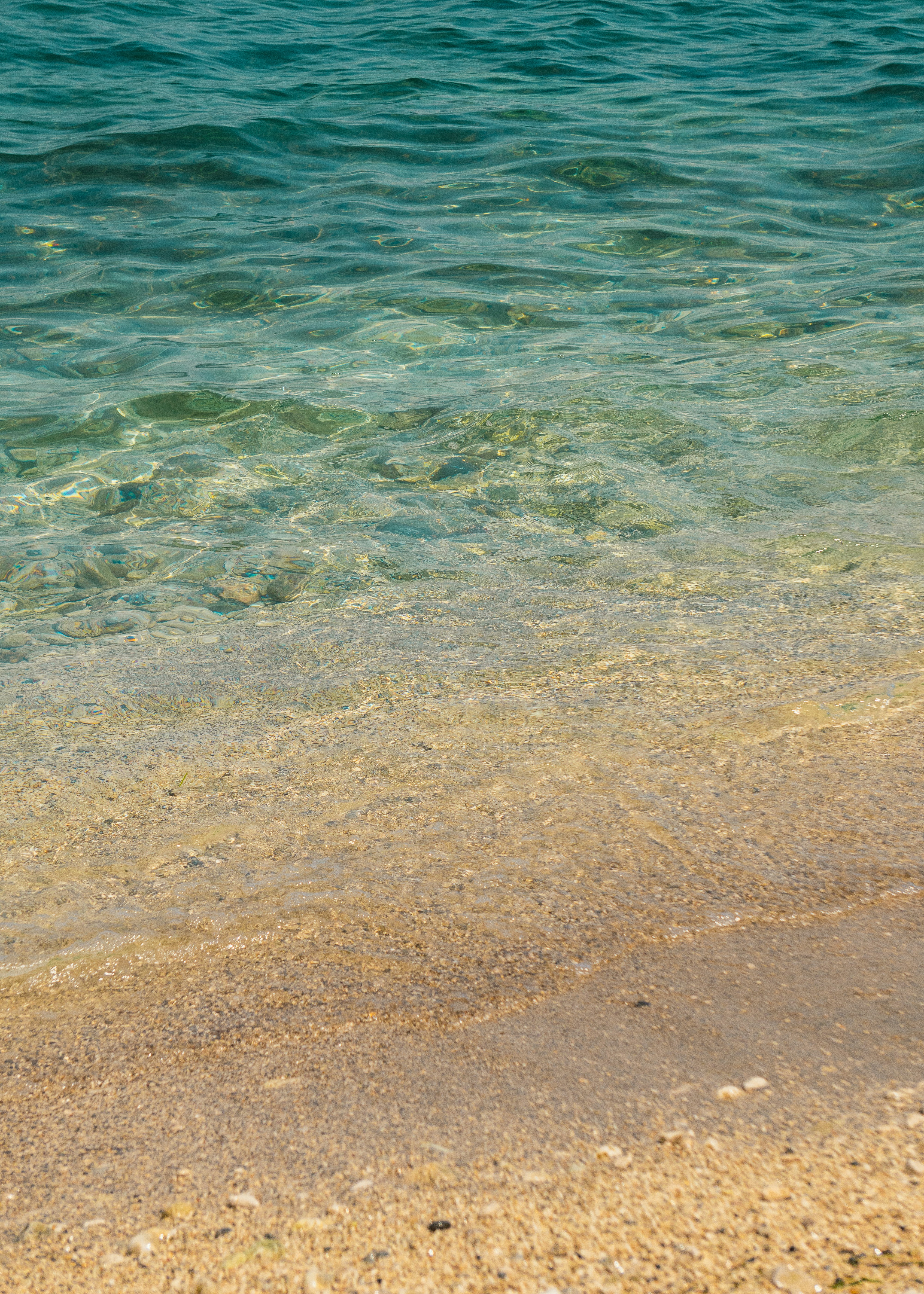 A person standing on a beach with a surfboard