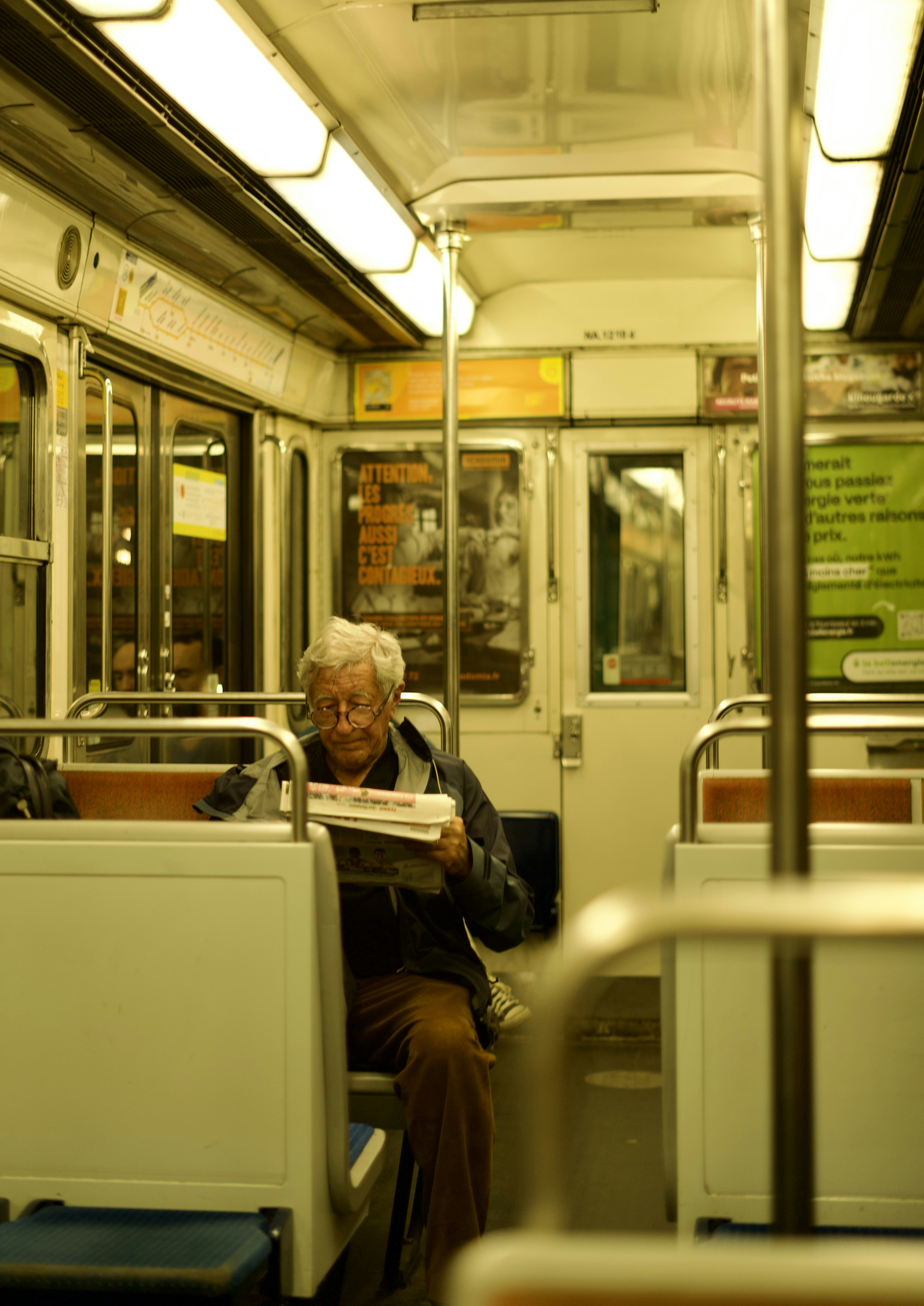 A man sitting on a train reading a newspaper