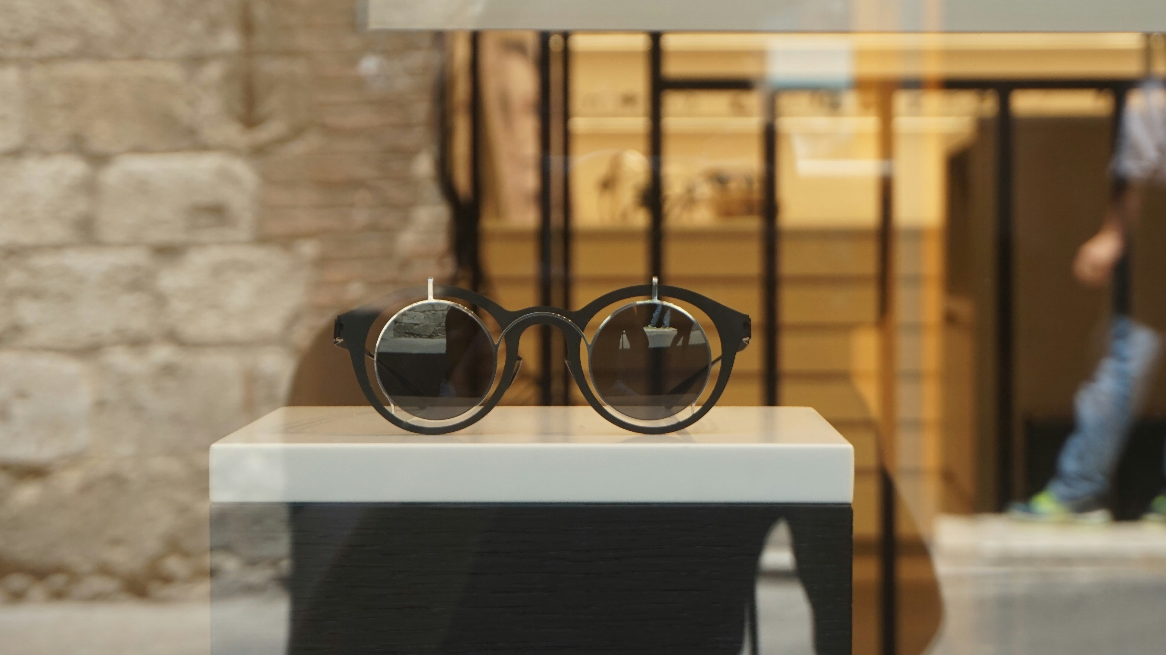 Stylish round minimalist sunglasses with gold frame on white surface