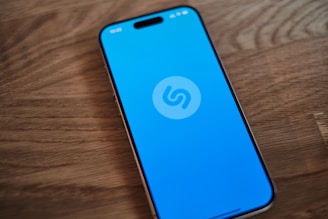 A blue phone sitting on top of a wooden table