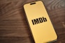 A yellow iPhone with the word imdb on it