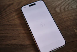 A close up of a cell phone on a wooden table