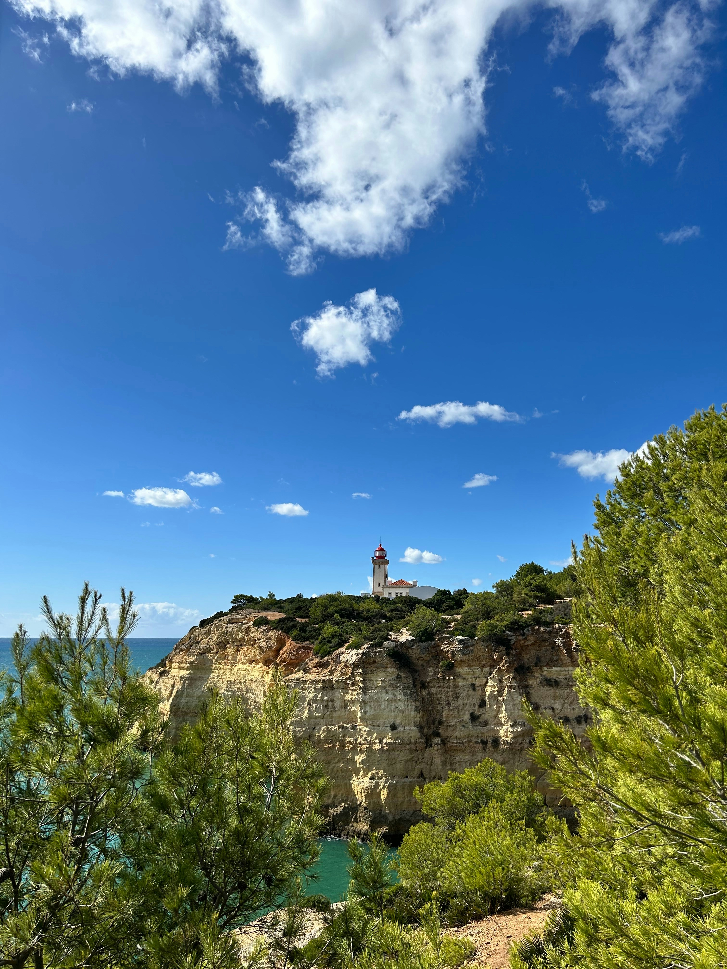 A scenic view of a lighthouse on top of a cliff