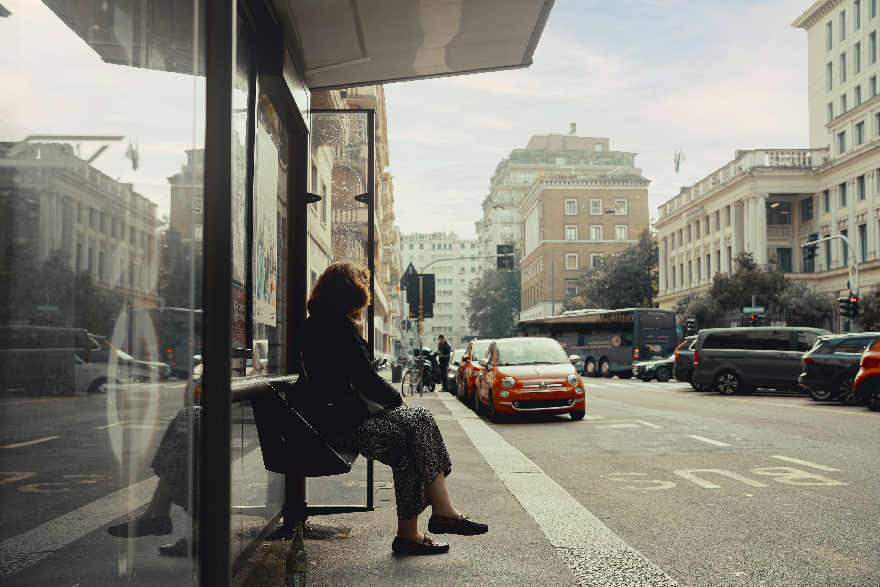 A woman sitting on a bench on a city street