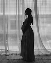 A pregnant woman standing in front of a window